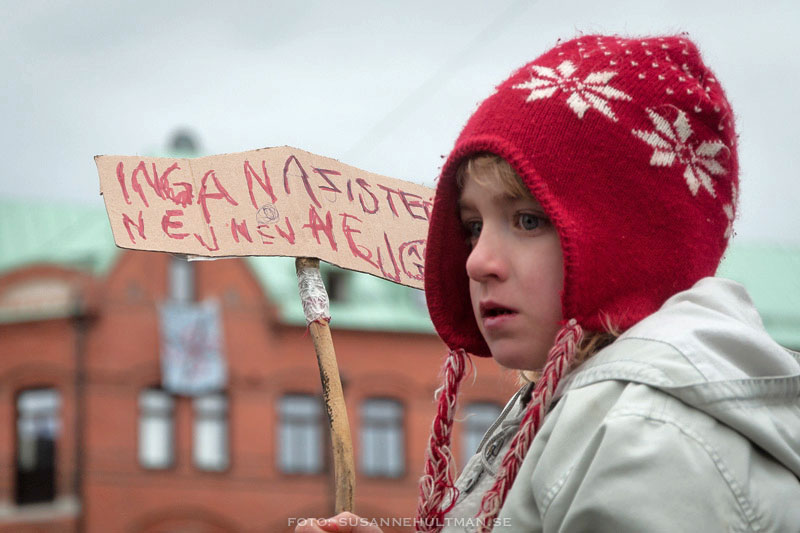 Flicka med handtextad skylt  med "Inga nazister. Nej, nej, nej"
