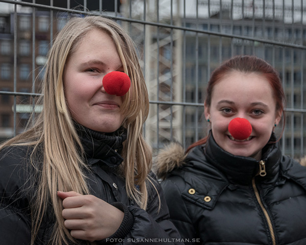 Två leende tjejer med röda clownnäsor