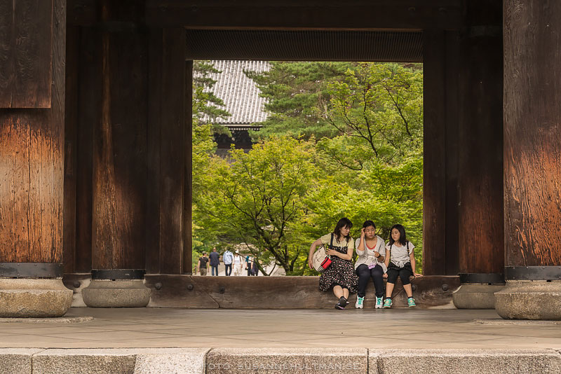 Tre flickor sitter vid Nanzenjitemplets port
