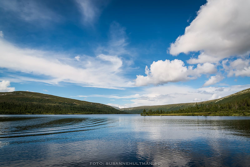 Klarblå himmel speglar sig i sjön