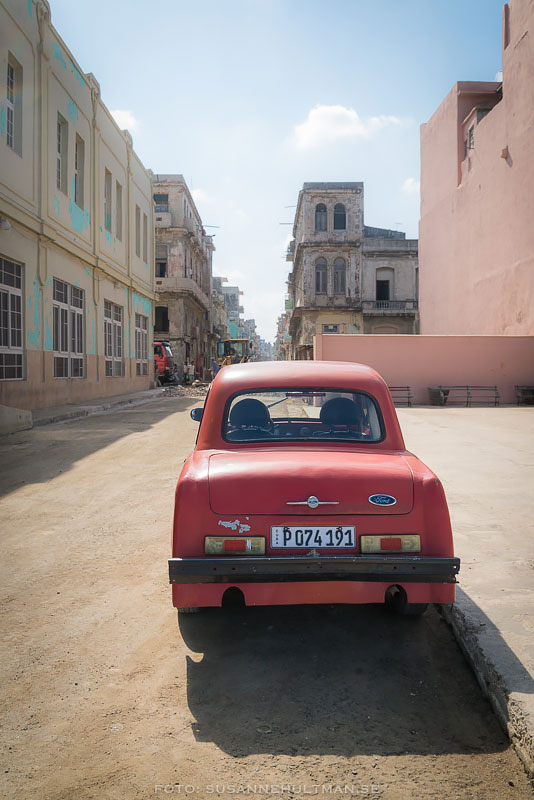 Röd gammal bil på gata