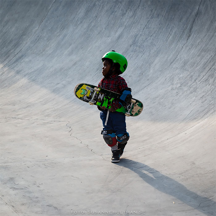 Pojke med skateboard i famnen