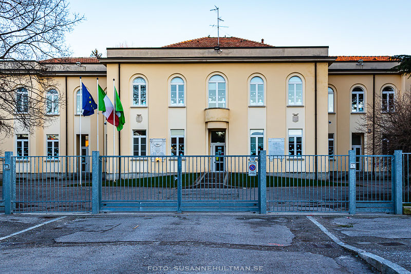 Skolbyggnad med flaggor till vänster