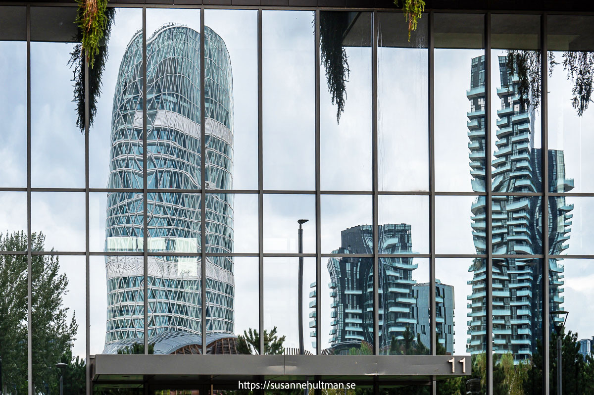 Speglingar i fönster av höga byggnader i Milano, Porta Nova.