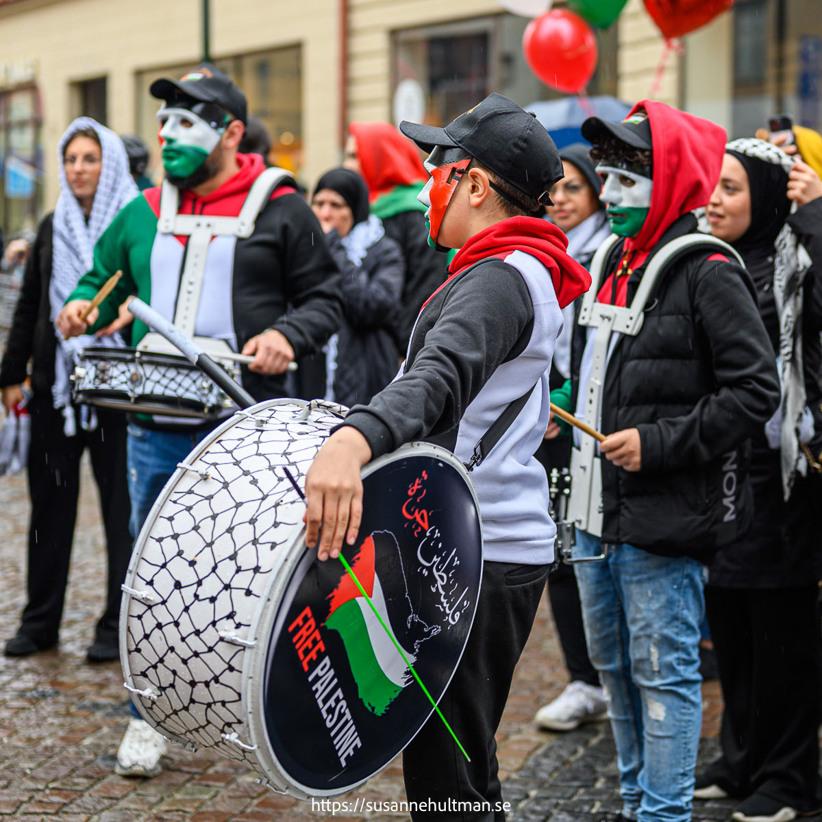 Maskerade män med trummor på demonstration för Palestina.